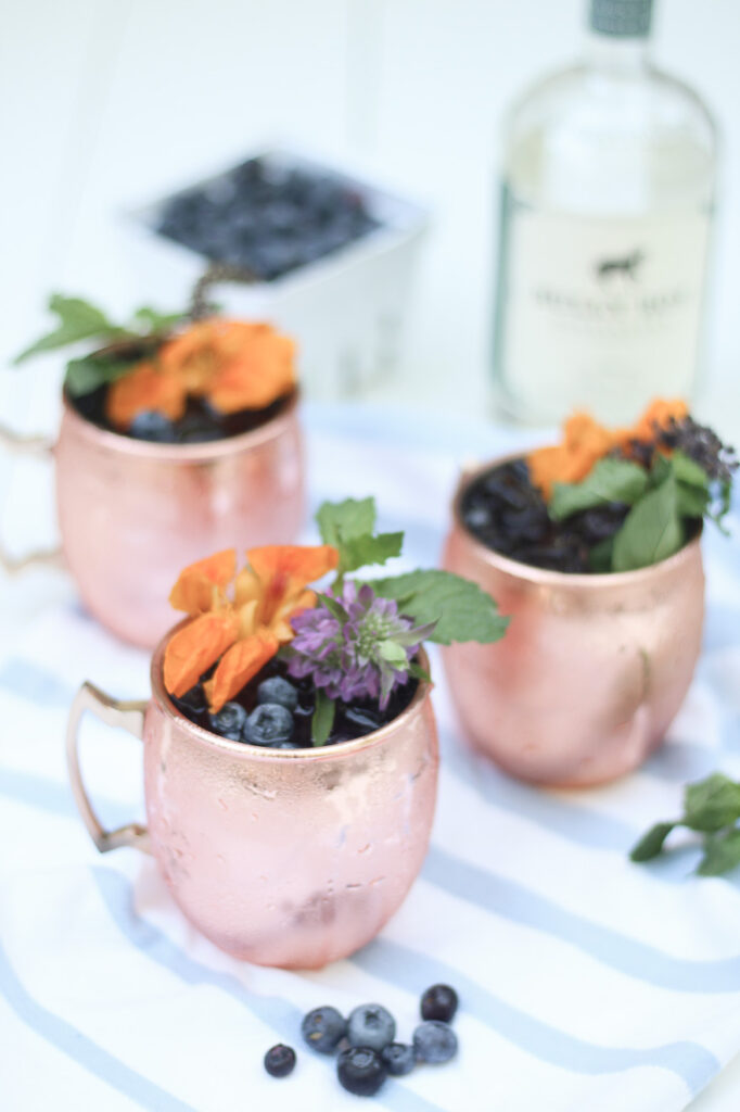 Blueberry Gin Mule with edible flowers